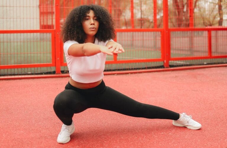 person stretching in lateral squat position