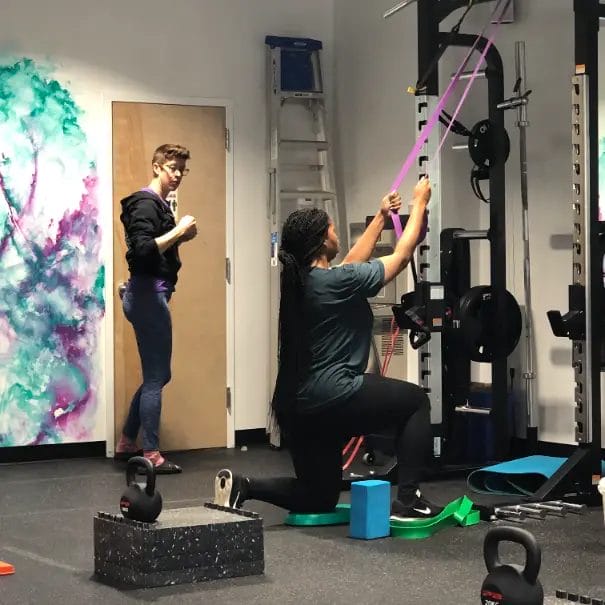 Reimagym personal training session with coach assisting member during workout