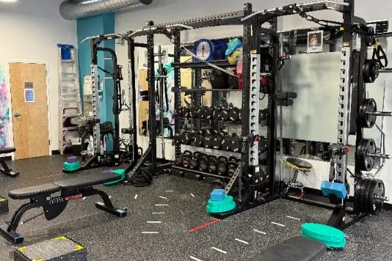 Reimagym strength training area with racks, weights and gym equipment